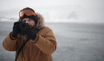 fotografo a inverno nel tempestoso tempo metereologico indossare caldo pelliccia giacca foto