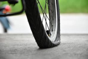 posteriore ruota di bicicletta quale è piatto e parcheggiata su il marciapiede accanto il strada. foto