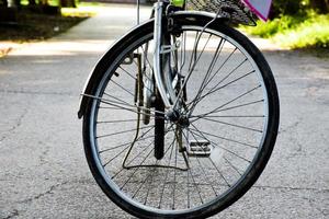 avvicinamento Visualizza di posteriore piatto pneumatico di Vintage ▾ bicicletta quale parcheggiata su marciapiede accanto il strada. morbido e selettivo messa a fuoco. foto