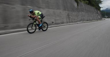 atleta di triathlon in sella a una bicicletta durante l'allenamento mattutino foto