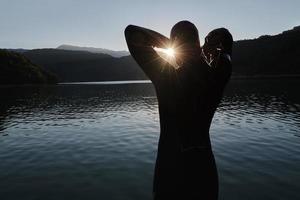 atleta di triathlon che inizia l'allenamento di nuoto sul lago foto