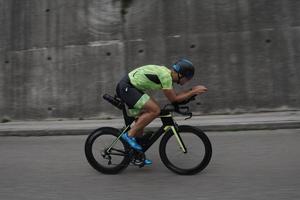 atleta di triathlon in sella a una bicicletta durante l'allenamento mattutino foto