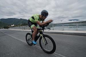 atleta di triathlon in sella a una bicicletta durante l'allenamento mattutino foto