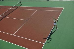 giovane donna giocare a tennis all'aperto foto