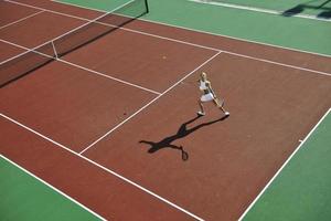 giovane donna giocare a tennis all'aperto foto