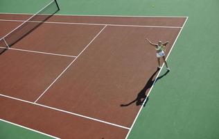 giovane donna giocare a tennis all'aperto foto