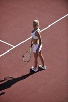 giovane donna giocare a tennis all'aperto foto