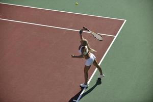 giovane donna giocare a tennis all'aperto foto