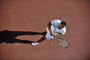 il giovane gioca a tennis foto