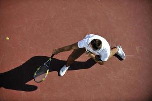 il giovane gioca a tennis foto