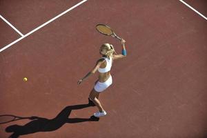 giovane donna giocare a tennis all'aperto foto