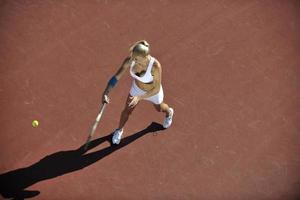 giovane donna giocare a tennis all'aperto foto