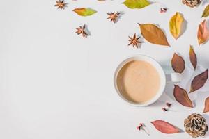 autunno o inverno concetto con pino e acero foglie, caffè tazza , cannella, e sciarpa, piatto posizione, superiore Visualizza. foto