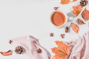 autunno o inverno concetto con pino e acero foglie, caffè tazza , cannella, e sciarpa, piatto posizione, superiore Visualizza. foto