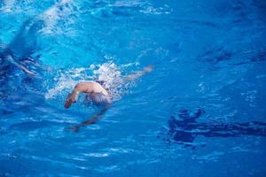 esercizio del nuotatore sulla piscina coperta foto