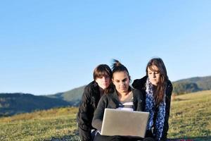 gruppo di adolescenti Lavorando su il computer portatile all'aperto foto