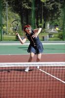 giovane donna giocare a tennis all'aperto foto