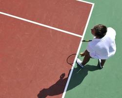 il giovane gioca a tennis all'aperto foto