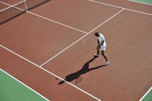 il giovane gioca a tennis foto