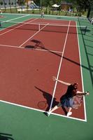 il giovane gioca a tennis all'aperto foto