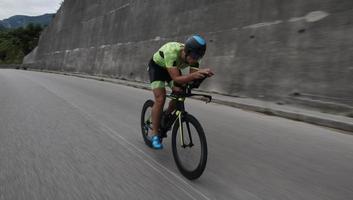 atleta di triathlon in sella a una bicicletta durante l'allenamento mattutino foto