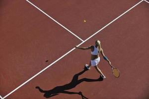 giovane donna giocare a tennis all'aperto foto