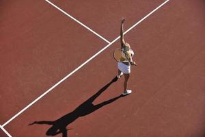 giovane donna giocare a tennis all'aperto foto