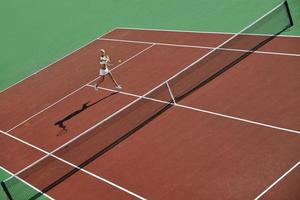 giovane donna giocare a tennis all'aperto foto