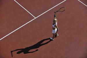 giovane donna giocare a tennis all'aperto foto