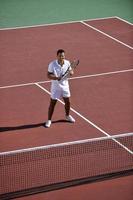 il giovane gioca a tennis foto