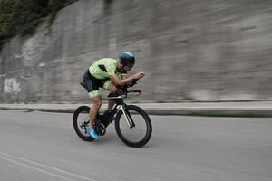 atleta di triathlon in sella a una bicicletta durante l'allenamento mattutino foto