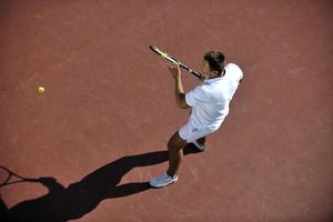 il giovane gioca a tennis foto