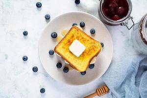 francese crostini con Banana, mirtillo, miele e fragola marmellata. delizioso mattina prima colazione o brunch con crostini e biscotti. superiore Visualizza foto