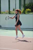 giovane donna giocare a tennis all'aperto foto