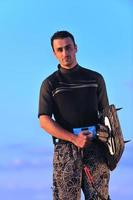 ritratto di un' giovane kitesurf uomo a spiaggia su tramonto foto
