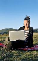 giovane ragazza adolescente lavora sul computer portatile all'aperto foto