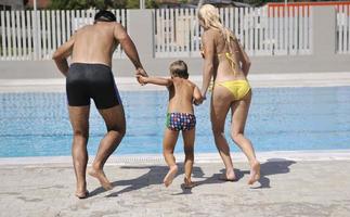 contento giovane famiglia avere divertimento su nuoto piscina foto