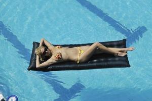donna rilassare su nuoto piscina foto