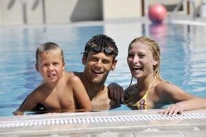 contento giovane famiglia avere divertimento su nuoto piscina foto