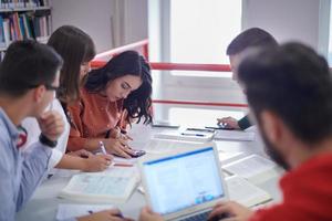 gruppo di studenti che lavorano insieme su un progetto scolastico su tablet presso l'università moderna foto