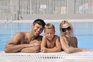 contento giovane famiglia avere divertimento su nuoto piscina foto