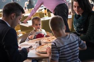 giovane genitori godendo pranzo tempo con loro bambini foto