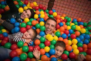 giovani genitori con bambini in una sala giochi per bambini foto