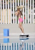 donna fitness esercizio a bordo piscina foto