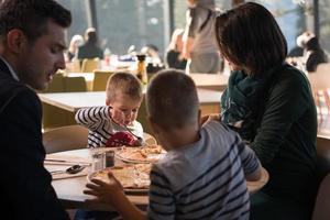 giovane genitori godendo pranzo tempo con loro bambini foto