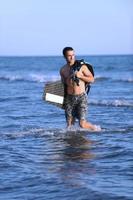 ritratto di un' giovane kitesurf uomo a spiaggia su tramonto foto