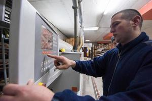 falegname che calcola e programma una macchina cnc per la lavorazione del legno foto