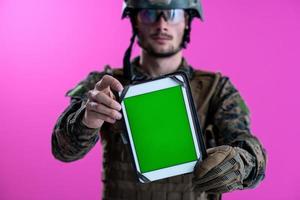 soldato mostrando un' tavoletta con un' vuoto verde schermo foto