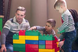 giovane genitori e bambini avendo divertimento a bambini stanza dei giochi foto