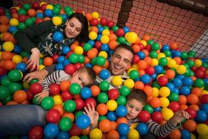 giovani genitori con bambini in una sala giochi per bambini foto